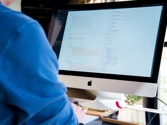 SM调教导航站团队在明亮的办公室内协作办公，屏幕上展示着sm调教内容分类索引界面，氛围专业而活力充沛